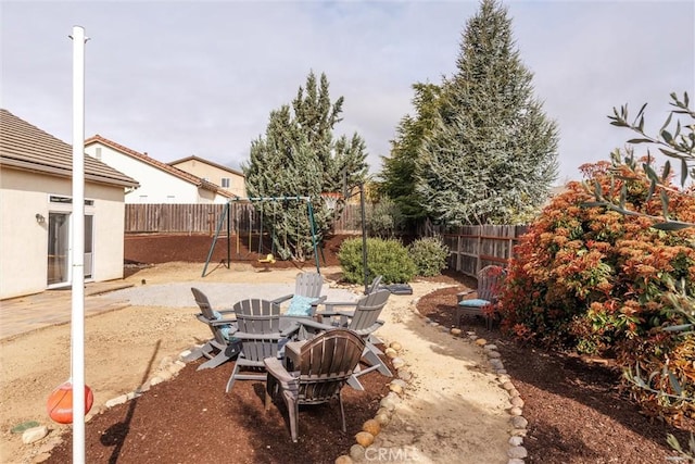 view of yard with a fenced backyard, a playground, and a patio
