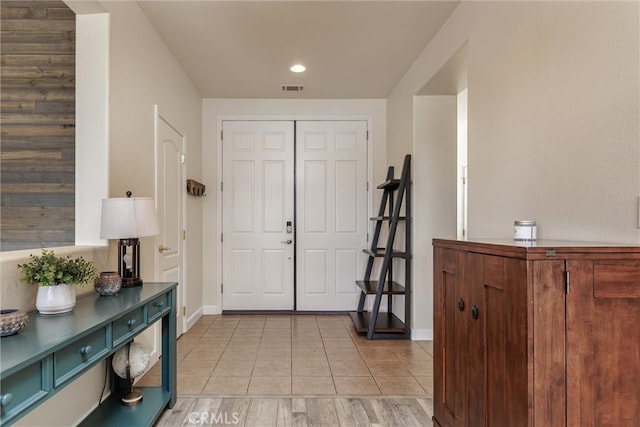 foyer with light tile patterned floors, baseboards, and visible vents