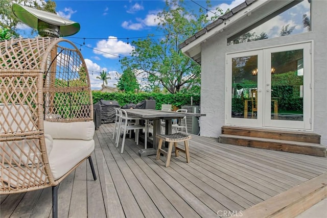 wooden terrace featuring french doors and outdoor dining area