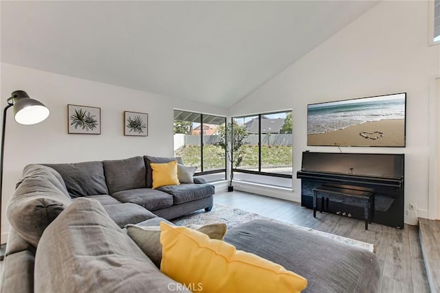 living area with wood finished floors and high vaulted ceiling