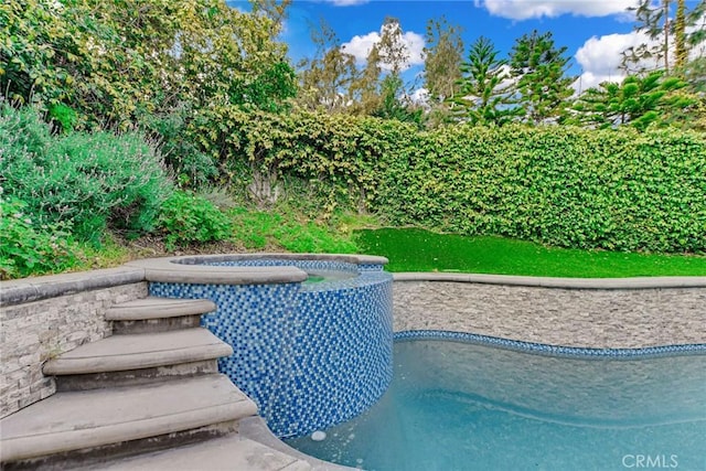 view of pool with a pool with connected hot tub