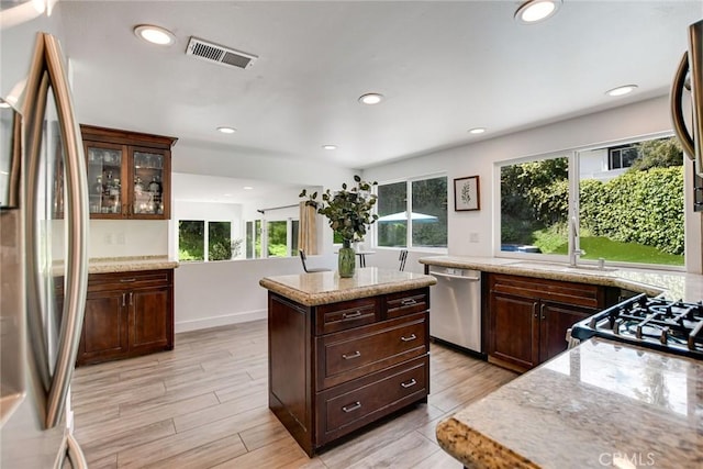 kitchen with stainless steel appliances, recessed lighting, dark brown cabinets, and light wood-style flooring