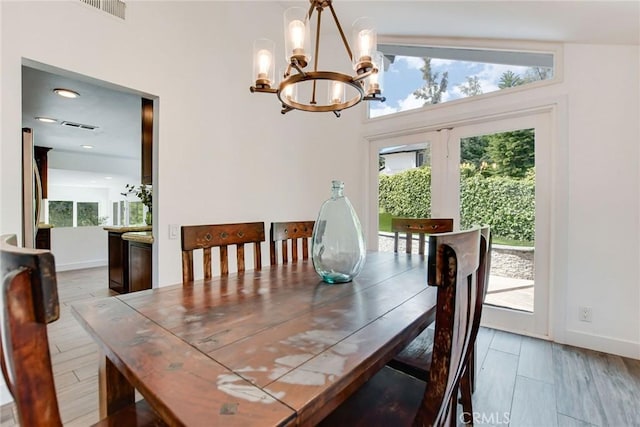 dining room with a chandelier, healthy amount of natural light, and baseboards