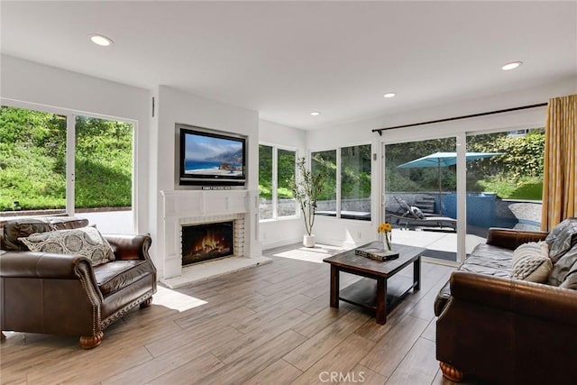living room with light wood-style floors, a fireplace, and recessed lighting
