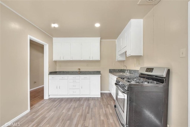 4026 Toland Way, Los Angeles, CA 90065 - kitchen with stainless steel range with gas stovetop, light wood finished floors, white cabinetry, a sink, and dark countertops