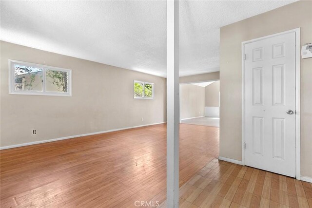 21032 Baltar St, Canoga Park, CA 91304 - below grade area with light wood-style flooring, baseboards, and a textured ceiling