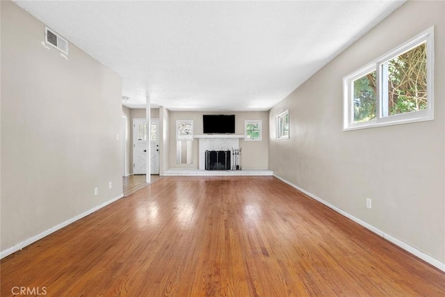 21032 Baltar St, Canoga Park, CA 91304 - unfurnished living room with light wood finished floors, baseboards, a fireplace, and visible vents