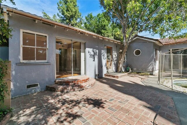 21032 Baltar St, Canoga Park, CA 91304 - rear view of house with a patio, a tile roof, a trampoline, and stucco siding