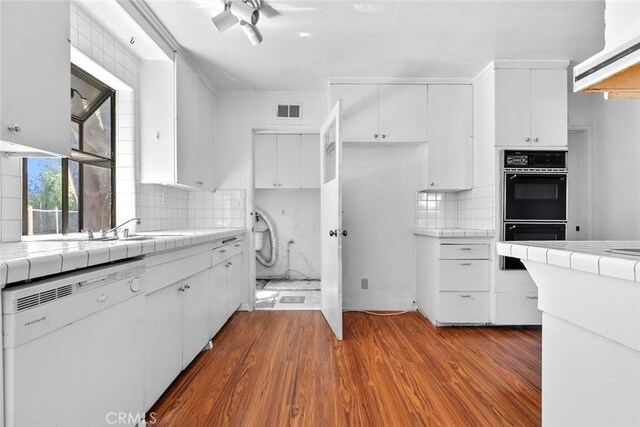 21032 Baltar St, Canoga Park, CA 91304 - kitchen featuring dobule oven black, tile countertops, and white dishwasher