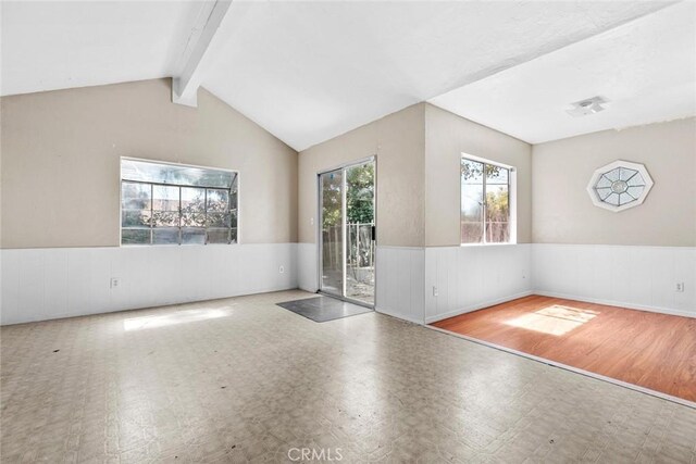 21032 Baltar St, Canoga Park, CA 91304 - spare room with tile patterned floors, a wainscoted wall, and lofted ceiling with beams