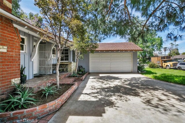 21032 Baltar St, Canoga Park, CA 91304 - view of front of home with driveway, a garage, a tiled roof, and stucco siding