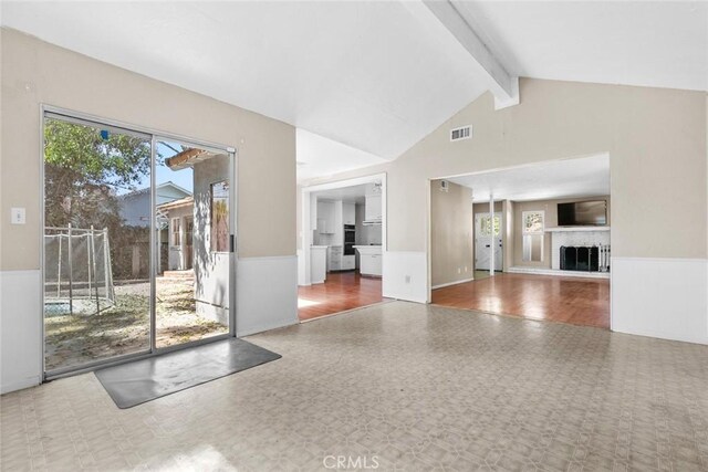 21032 Baltar St, Canoga Park, CA 91304 - unfurnished living room with high vaulted ceiling, visible vents, beamed ceiling, tile patterned floors, and wainscoting
