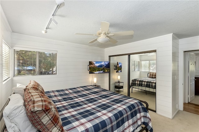 279 Bluebird Ct, Big Bear Lake, CA 92315 - bedroom with rail lighting, light colored carpet, a textured ceiling, ceiling fan, and a closet