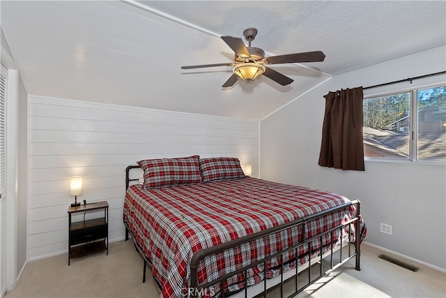 279 Bluebird Ct, Big Bear Lake, CA 92315 - carpeted bedroom with a ceiling fan, wooden walls, a textured ceiling, baseboards, and visible vents