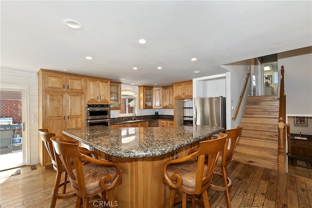 279 Bluebird Ct, Big Bear Lake, CA 92315 - kitchen with a sink, appliances with stainless steel finishes, glass insert cabinets, dark stone countertops, and light wood-style floors