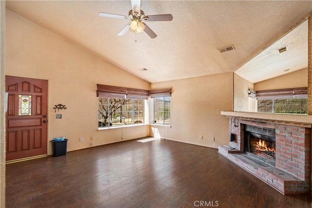 14935 Elizabeth Lake Rd, Lake Elizabeth, CA 93532 - unfurnished living room featuring vaulted ceiling, visible vents, a brick fireplace, ceiling fan, and wood finished floors