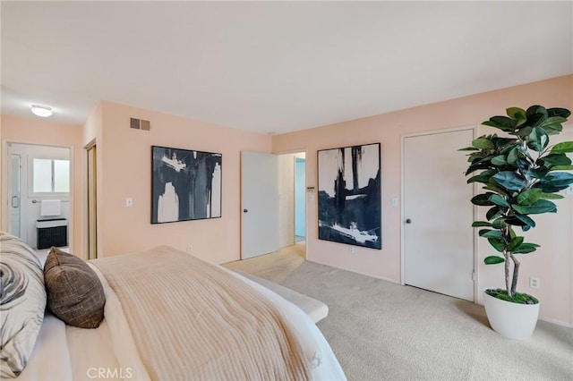 bedroom featuring visible vents, connected bathroom, and light carpet