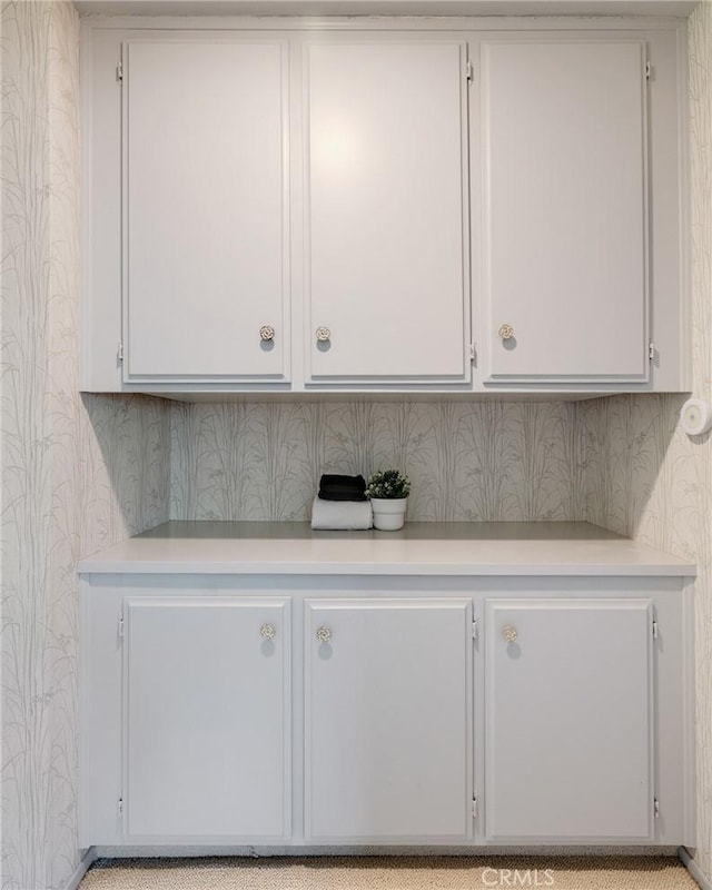 clothes washing area with wallpapered walls