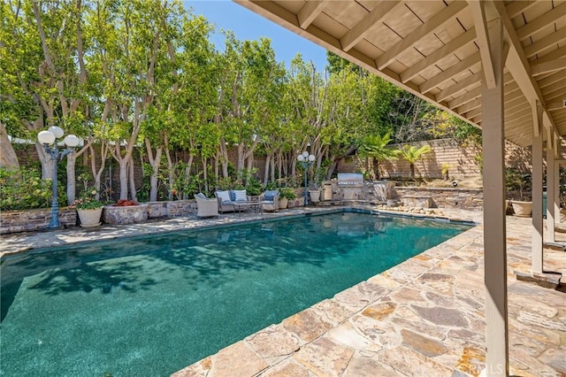 pool featuring a patio area, a fenced backyard, and area for grilling