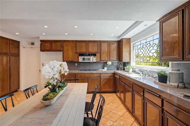 kitchen with light tile patterned floors, recessed lighting, a sink, stainless steel appliances, and backsplash