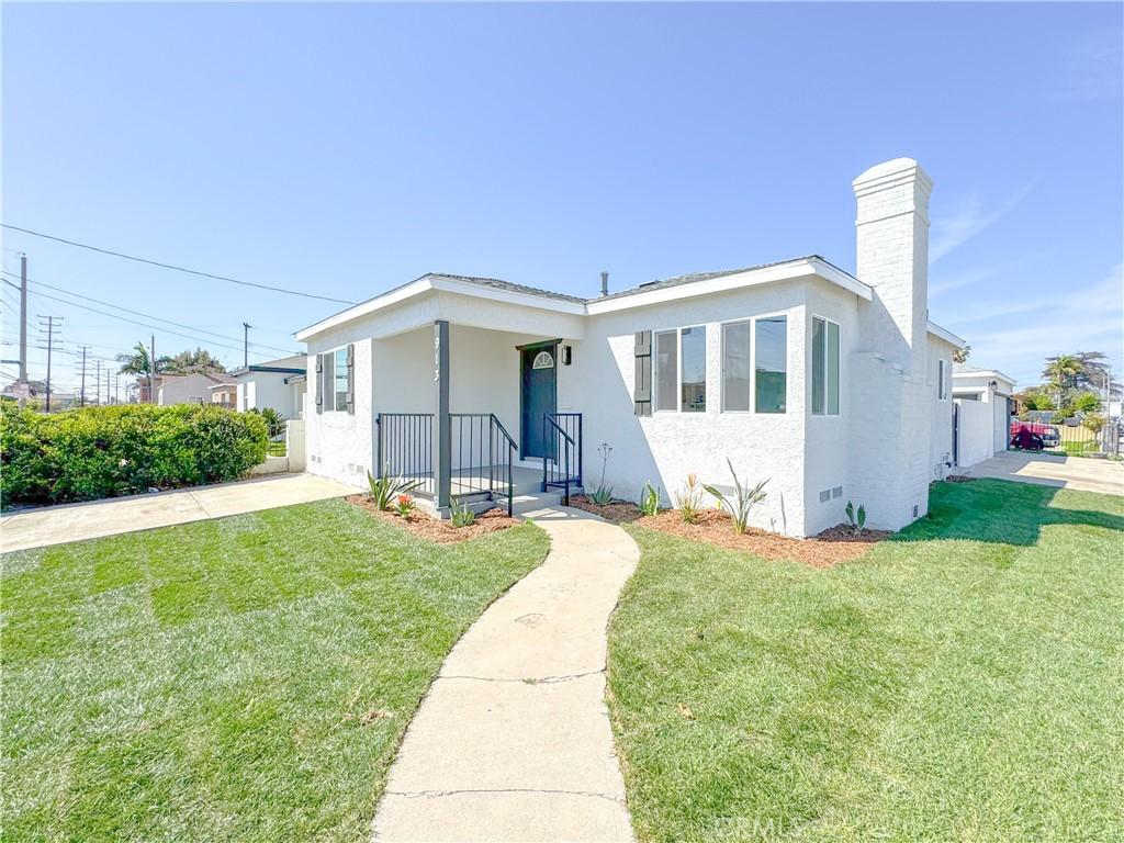 913 E Elm St, Compton, CA 90221 - view of front facade featuring a front yard, stucco siding, and a chimney