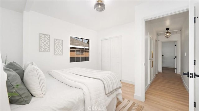 bedroom featuring a closet, baseboards, and light wood-style floors