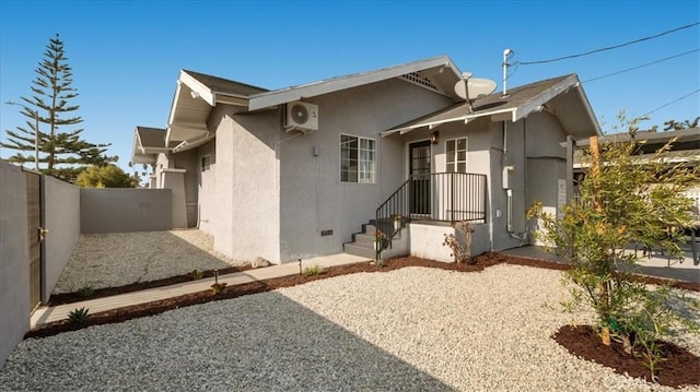 back of property with stucco siding and fence
