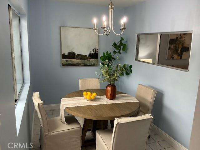 4522 W 156th St, Lawndale, CA 90260 - dining area with a chandelier, baseboards, and tile patterned flooring
