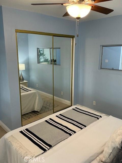 bedroom with a closet, baseboards, and ceiling fan