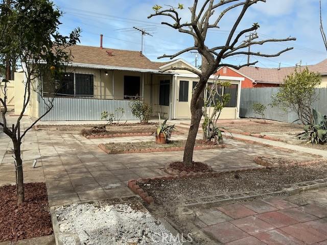 single story home featuring roof with shingles and fence