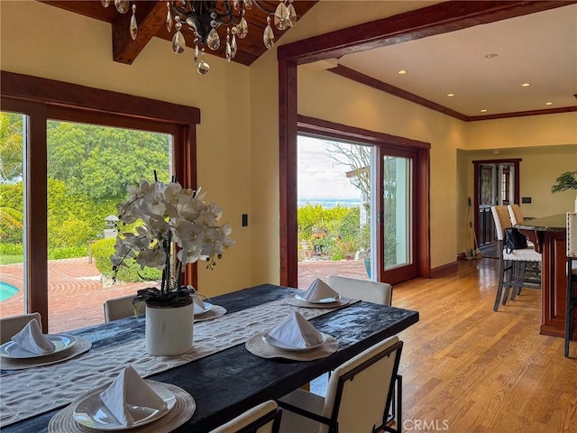 dining area featuring baseboards, an inviting chandelier, light wood-style flooring, and plenty of natural light