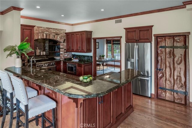 2501 Novato Pl, Palos Verdes Estates, CA 90274 - kitchen featuring stainless steel appliances, a peninsula, wood finished floors, dark stone countertops, and recessed lighting
