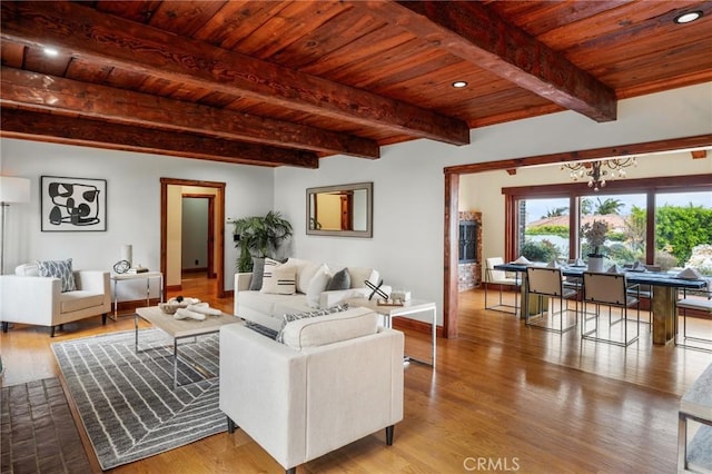 living area featuring wooden ceiling, beam ceiling, wood finished floors, and baseboards