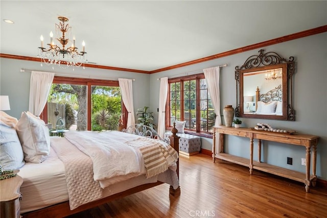 bedroom with a chandelier, ornamental molding, wood finished floors, and multiple windows