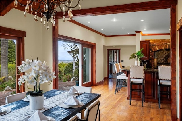 dining space with an inviting chandelier, a healthy amount of sunlight, and light wood-style floors
