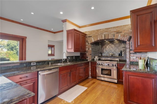kitchen featuring recessed lighting, decorative backsplash, stainless steel appliances, a sink, and crown molding
