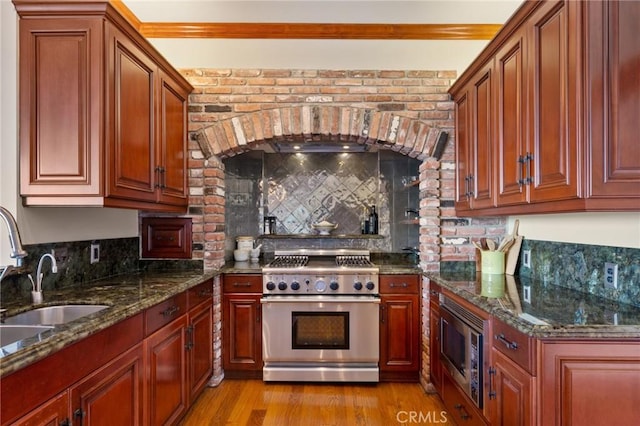 2501 Novato Pl, Palos Verdes Estates, CA 90274 - kitchen with appliances with stainless steel finishes, a sink, tasteful backsplash, light wood finished floors, and dark stone countertops