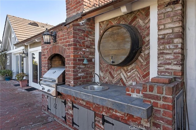 view of patio / terrace featuring a grill and a sink