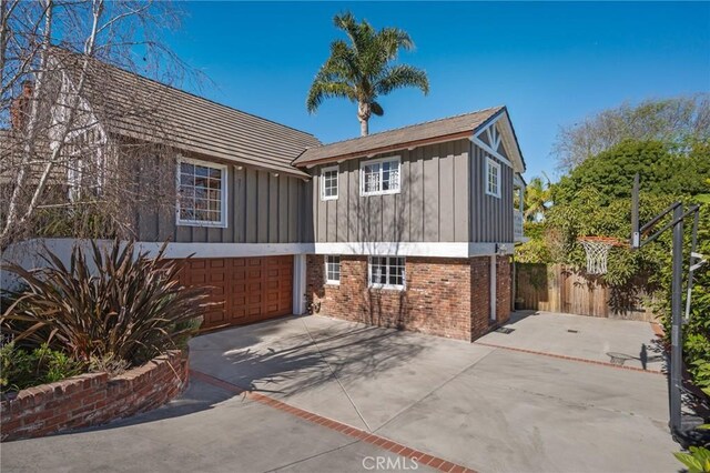 2501 Novato Pl, Palos Verdes Estates, CA 90274 - back of property with driveway, brick siding, board and batten siding, and an attached garage