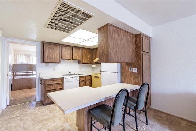 3332 Harbor Cir Unit C, Paso Robles, CA 93446 - kitchen with white appliances, a breakfast bar, light countertops, a sink, and under cabinet range hood