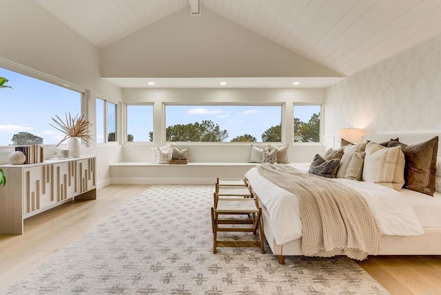 bedroom featuring beam ceiling, high vaulted ceiling, multiple windows, and wood finished floors