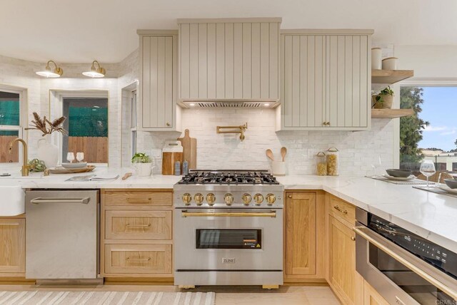 kitchen with appliances with stainless steel finishes, decorative backsplash, light stone counters, and open shelves