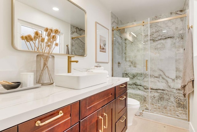 full bathroom with toilet, a marble finish shower, and vanity