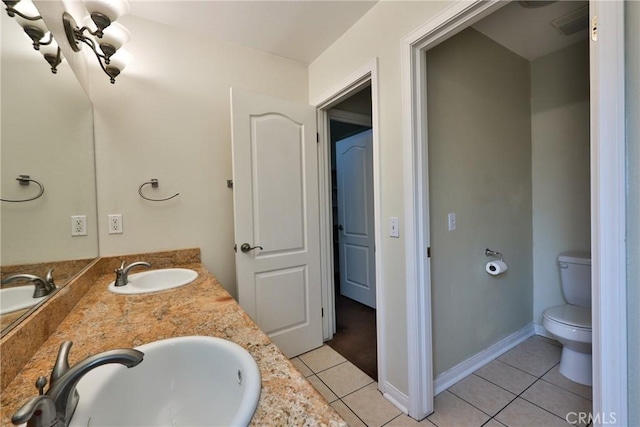 full bath with toilet, tile patterned floors, double vanity, and a sink