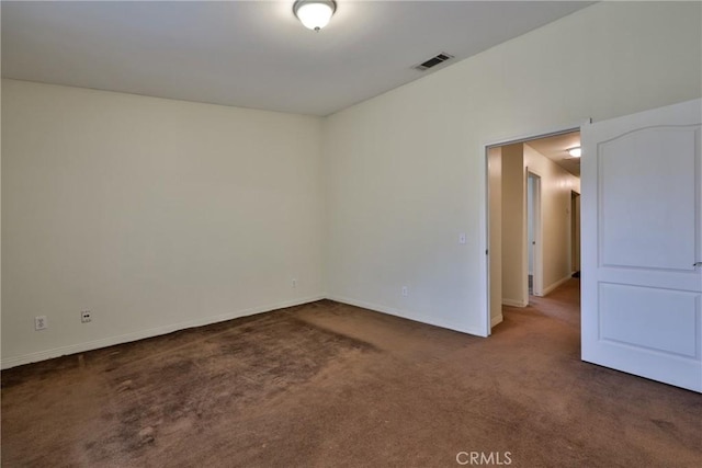 empty room with visible vents, baseboards, and carpet