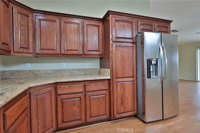 5420 Chiquita Ln, San Bernardino, CA 92404 - kitchen with stainless steel fridge, light wood-style flooring, and light stone countertops