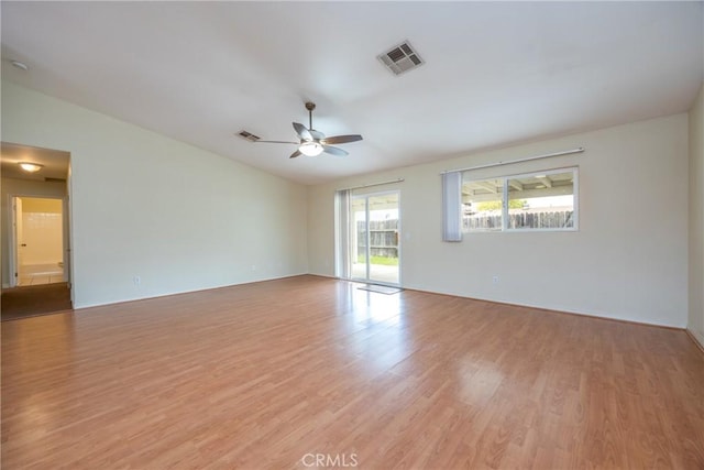 unfurnished room with visible vents, ceiling fan, light wood-type flooring, and vaulted ceiling