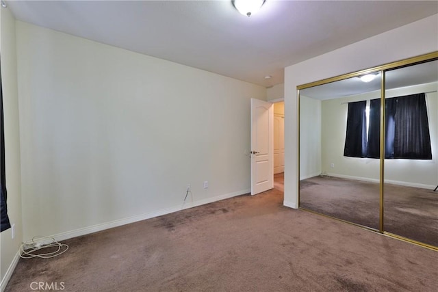 unfurnished bedroom featuring carpet, a closet, and baseboards
