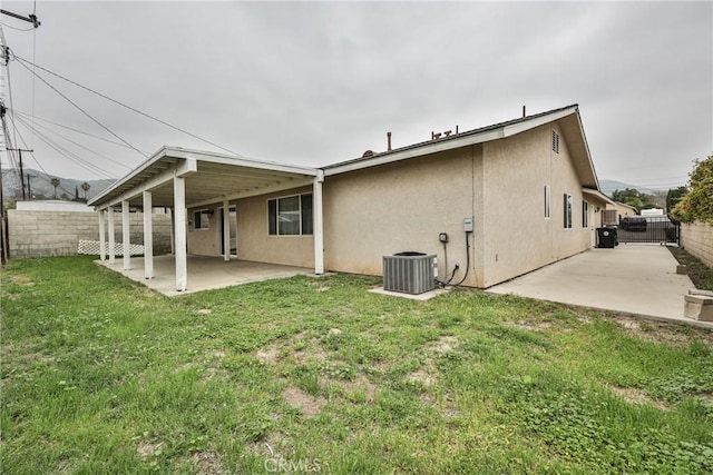 back of property with a yard, fence, cooling unit, a patio, and stucco siding