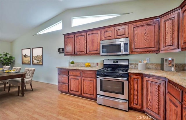 5420 Chiquita Ln, San Bernardino, CA 92404 - kitchen featuring appliances with stainless steel finishes, light wood-type flooring, high vaulted ceiling, and brown cabinets